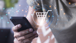 hand holding a mobile phone with a shopping cart icon overlay