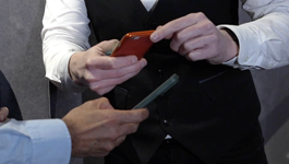 closeup of hands for two people holding a phone to scan